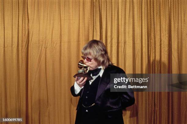 American songwriter Paul Williams kissing his trophy during the 20th Anniversary Grammy Awards at the Shrine Auditorium, Los Angeles, California,...