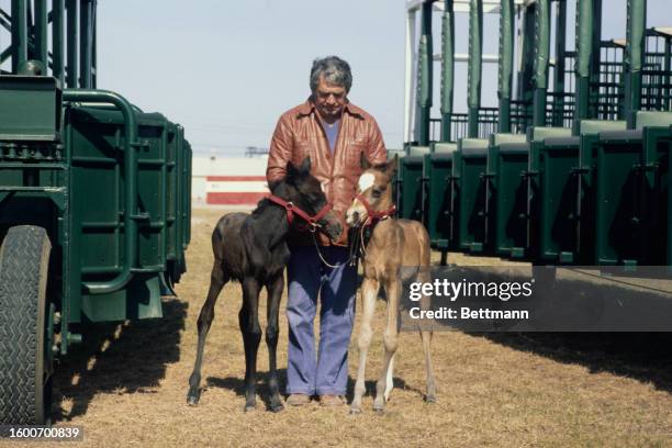 Groom Miki Martyniak posing with twin foals Delilah and Sampson at Meadowlands racetrack in East Rutherford, New Jersey, March 31st 1978. The colts,...