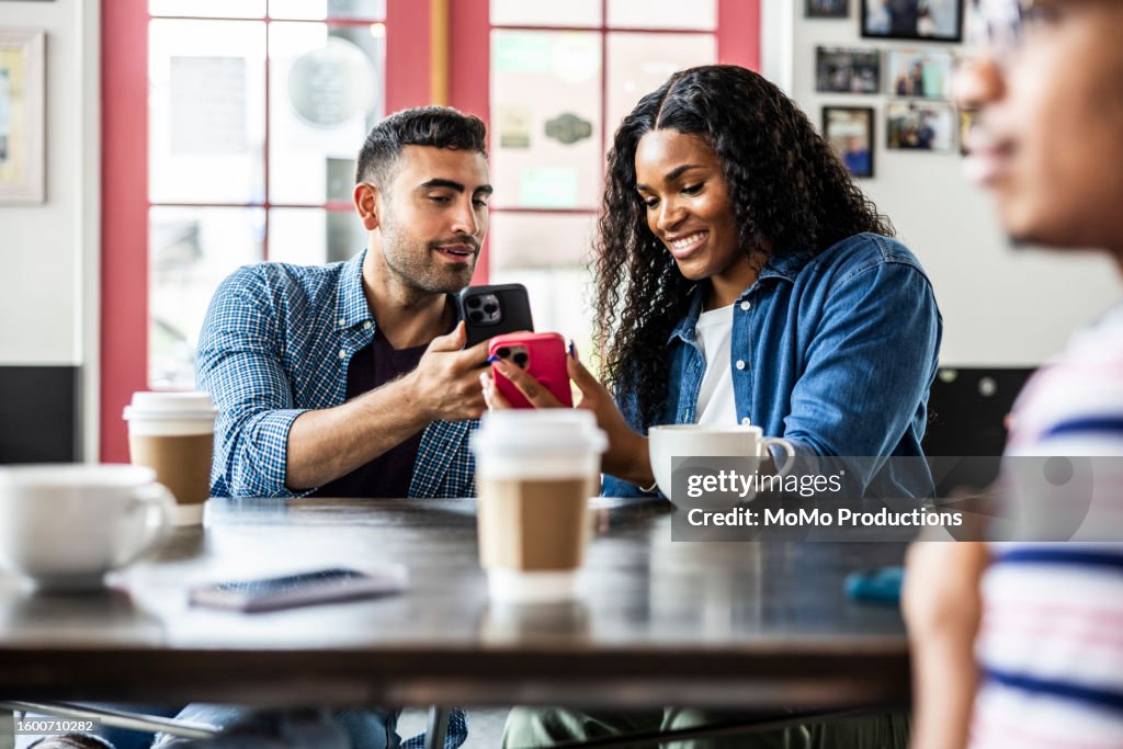Young couple using smartphones to transfer money