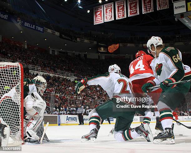 Josh Harding of the Minnesota Wild tries to find the puck between teamates Ryan Suter and Mikael Granlund while Todd Bertuzzi of the Detroit Red...