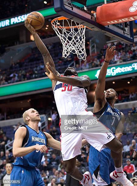 Washington Wizards center Emeka Okafor scores over Minnesota Timberwolves center Greg Stiemsma , left and power forward Derrick Williams during the...