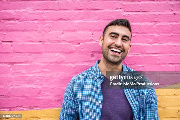 portrait of young generation z man standing against brightly colored wall - attitude stock pictures, royalty-free photos & images