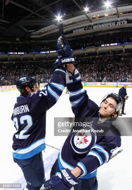 Chris Thorburn and Alexander Burmistrov of the Winnipeg Jets celebrate with a high-five following a 4-2 victory over the Pittsburgh Penguins at the...