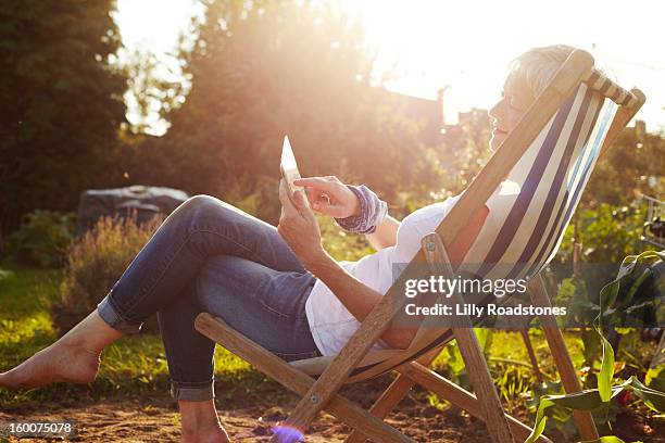 woman using tablet computer on allotment - garden ipad stock pictures, royalty-free photos & images