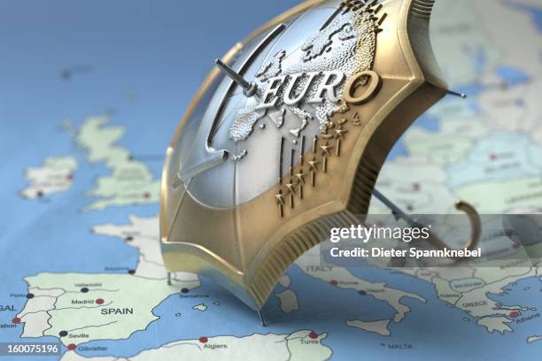 euro coin designed umbrella on a map of europe - schuldencrisis eurozone stockfoto's en -beelden