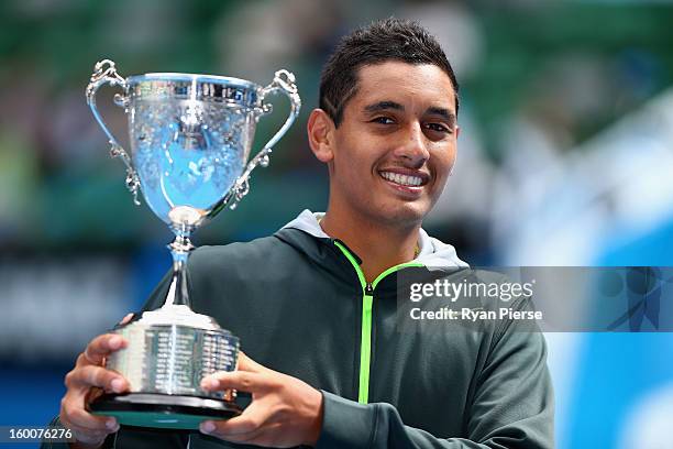 Nick Kyrgios of Australia celebrates with the championship trophy after winning his junior boys' final match against Thanasi Kokkinakis of Australia...