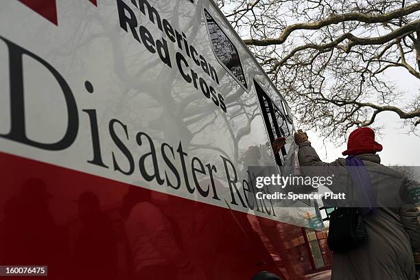 Woman takes a bag of food from a Red Cross Disaster Relief truck in the Rockaways following Hurricane Sandy on January 25, 2013 in the Queens borough...