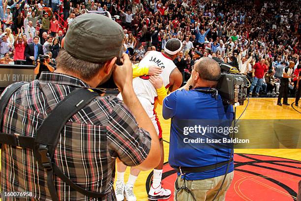 LeBron James of the Miami Heat hugs fan Michael Drysch after Drysch made a half-court shot to win $75,000 for himself and $75,000 for the LeBron...