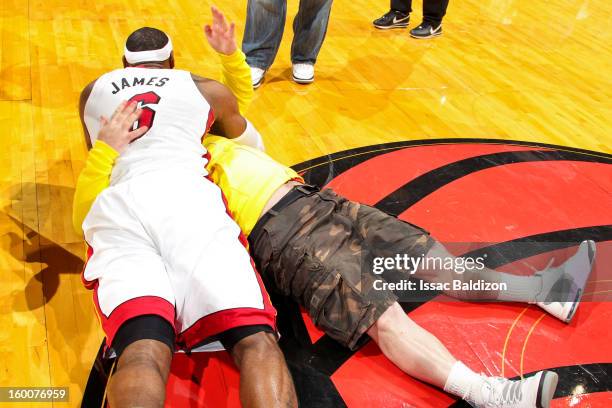 LeBron James of the Miami Heat embraces fan Michael Drysch after Drysch made a half-court shot to win $75,000 for himself and $75,000 for the LeBron...