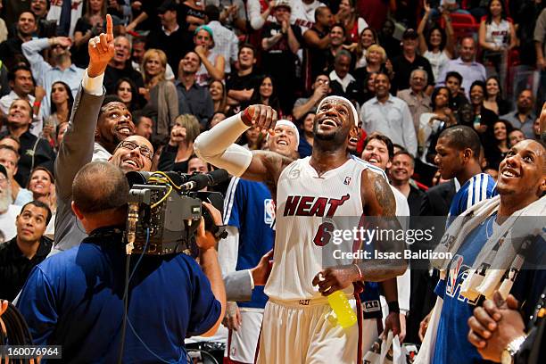 LeBron James of the Miami Heat celebrates after fan Michael Drysch made a half-court shot to win $75,000 for himself and $75,000 for the LeBron James...