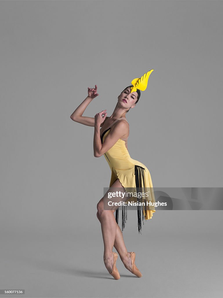 Ballerina on point in yellow bird dress