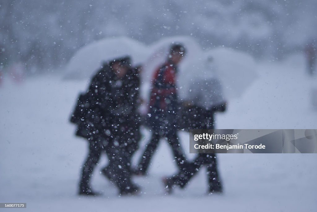 People with plastic umbrellas in snow