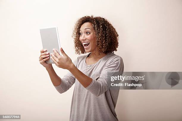 woman using digital tablet - surprised woman looking at tablet stock pictures, royalty-free photos & images