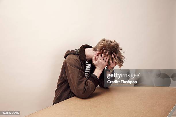 portrait of man with his head in his hands - depression anxiety stock pictures, royalty-free photos & images