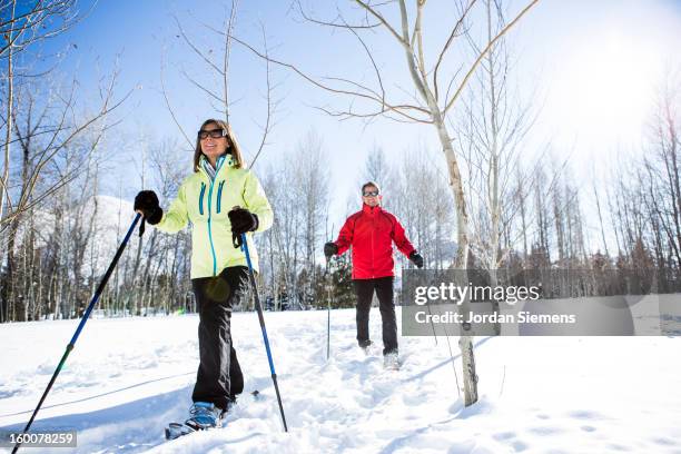 older couple snowshoeing in the winter. - winter sport walk old stock pictures, royalty-free photos & images