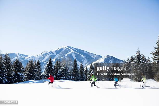 a family snowshoeing in the winter. - sun valley stock-fotos und bilder