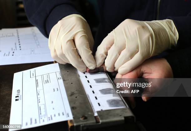 A Forensics expert takes the fingerprints of a person during a mock exercise to present the work of a Police Technique et Scientifique unit, on...