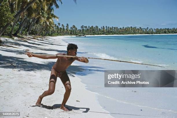 Fisherman aims his spear at the Blue Lagoon on the Yasawa Islands in Fiji, circa 1965.