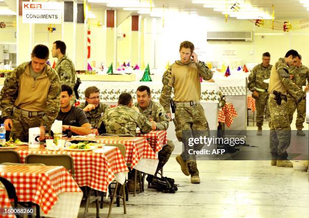 This picture taken on December 11, 2012 shows Britain's Prince Harry walking past in the dining facility at Camp Bastion in Afghanistan's Helmand...