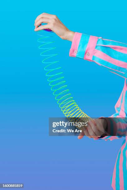 hands holding flexible slinky - abstract pattern stock pictures, royalty-free photos & images