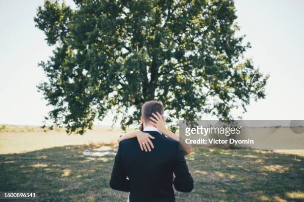 huge green tree behind the kissing couple - oak tree silhouette stock pictures, royalty-free photos & images