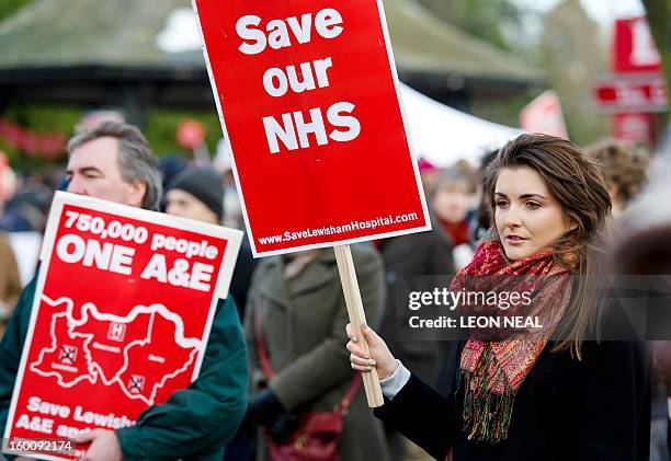 Demonstrators display placards as they march past in South-East London on January 26, 2013 to protest against the proposed closure of the Accident...