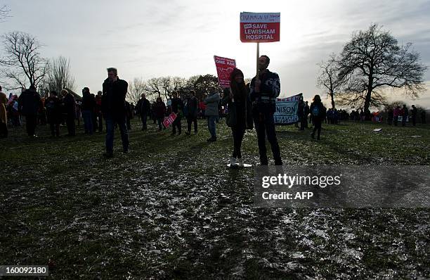 Demonstrators display placards as they march past in South-East London on January 26, 2013 to protest against the proposed closure of the Accident...