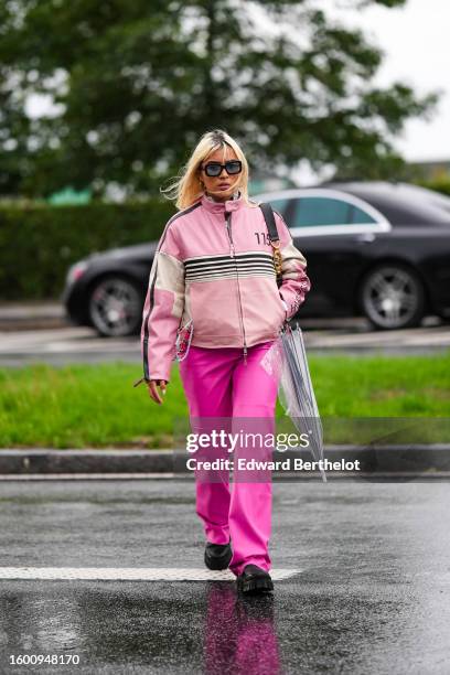 Guest wears black and navy blue squared sunglasses, a gray velvet ribbed high neck zipper pullover, a pale pink with black and beige striped print...