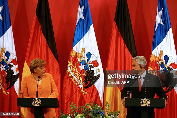 German Chancellor Angela Merkel and Chilean President Sebastian Pinera, look at each other during a ceremony at La Moneda presidential palace in...