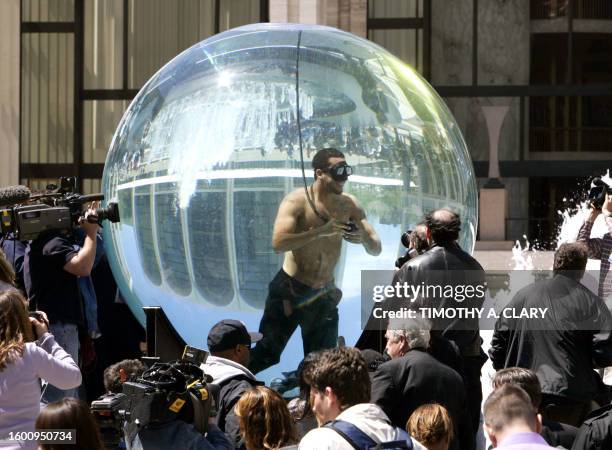 International performance artist and magician David Blaine floats inside a glass sphere filled with water 01 May 2006 at Lincoln Center in New York...