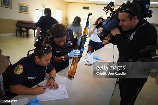 City of Miami police officers Angiee Fermin and Michaelle Bell process an AK-47 that was turned in during a gun buy back event on January 26, 2013 in...
