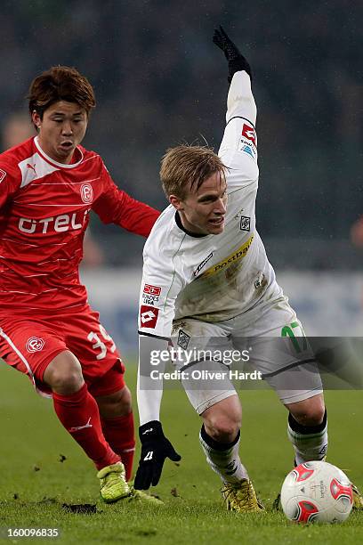 Oscar Wendt of Gladbach and Genki Omae of Duesseldorf battle for the ball during at Bundesliga match between VfL Borussia Moenchengladbach v Fortuna...