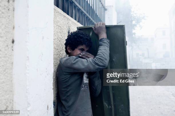 An Egyptian protester suffers from exposure to tear gas fired by Egyptian riot police during a protest following the announcement of the death...