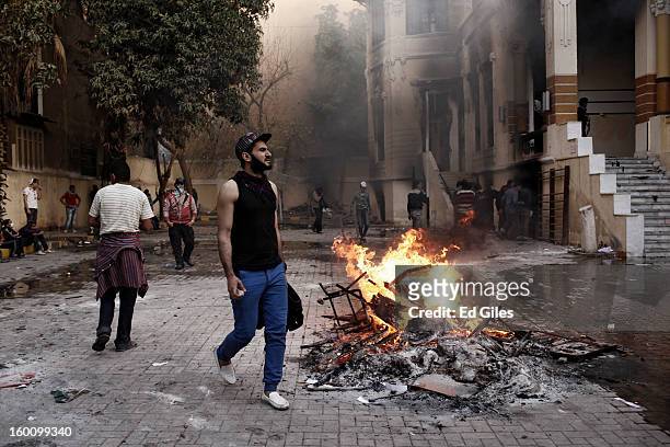 An Egyptian protester walks past a fire lit in the grounds of a school during a protest following the announcement of the death penalty for 21...