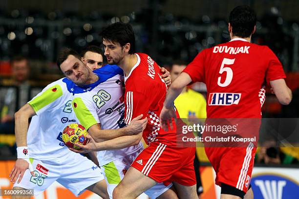 Luka Zvizej of Slovenia defends against Marko Kopljar of Croatia during the Men's Handball World Championship 2013 third place match between Slovenia...