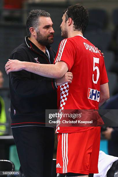 Head coach Brosi Denic of Slovenia embraces Domagoj Duvnjak of Croatia after the Men's Handball World Championship 2013 third place match between...