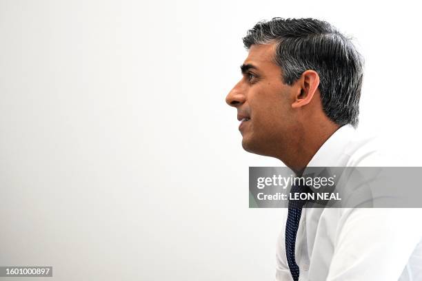 Britain's Prime Minister Rishi Sunak speaks to a patient in the SDEC unit, during a visit to Milton Keynes University Hospital in Milton Keynes,...