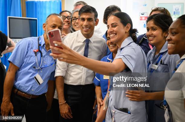 Britain's Prime Minister Rishi Sunak poses for a selfie photograph with members of staff in the SDEC unit, during a visit to Milton Keynes University...