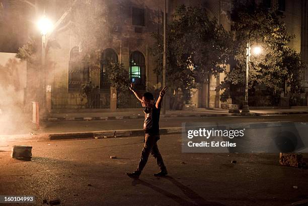 An Egyptian protester gestures toward Egyptian riot police during a protest following the announcement of the death penalty for 21 suspects in...