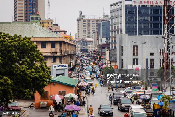 Pedestrians walk between office buildings in the Central Business District of Lagos, Nigeria, on Monday, Aug. 14, 2023. Nigerian President Bola...