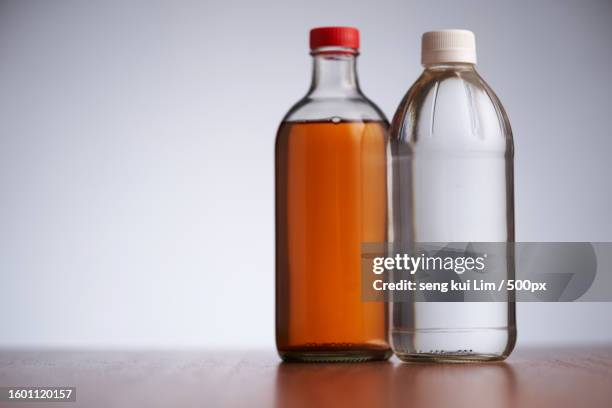 close-up of bottles against gray background - vinegar stockfoto's en -beelden