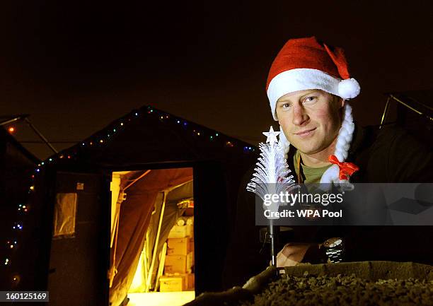 In this previously unissued image released on January 27 Prince Harry poses with a Christmas hat as he stands outside the VHR tent at Camp Bastion on...