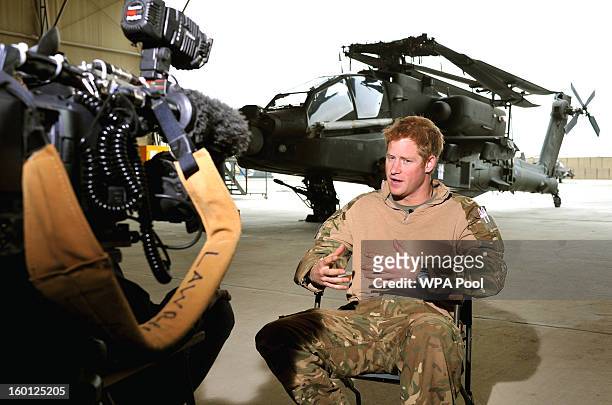 In this previously unissued image released on January 27 Prince Harry gives a TV interview in an Apache repair hanger on the flight-line at Camp...