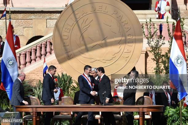 Paraguay's new President Santiago Peña shakes hands with Senate President Silvio Ovelar during his inauguration at the esplanade of Lopez...