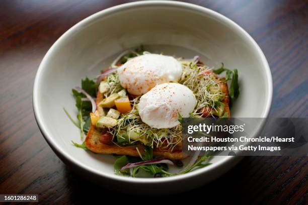 Avocado Toast-healthy grain, avocado, cucumber, tomatoes, alfalfa sprouts, arugula with two poached eggs at Bosta Kitchen, which is the new concept...