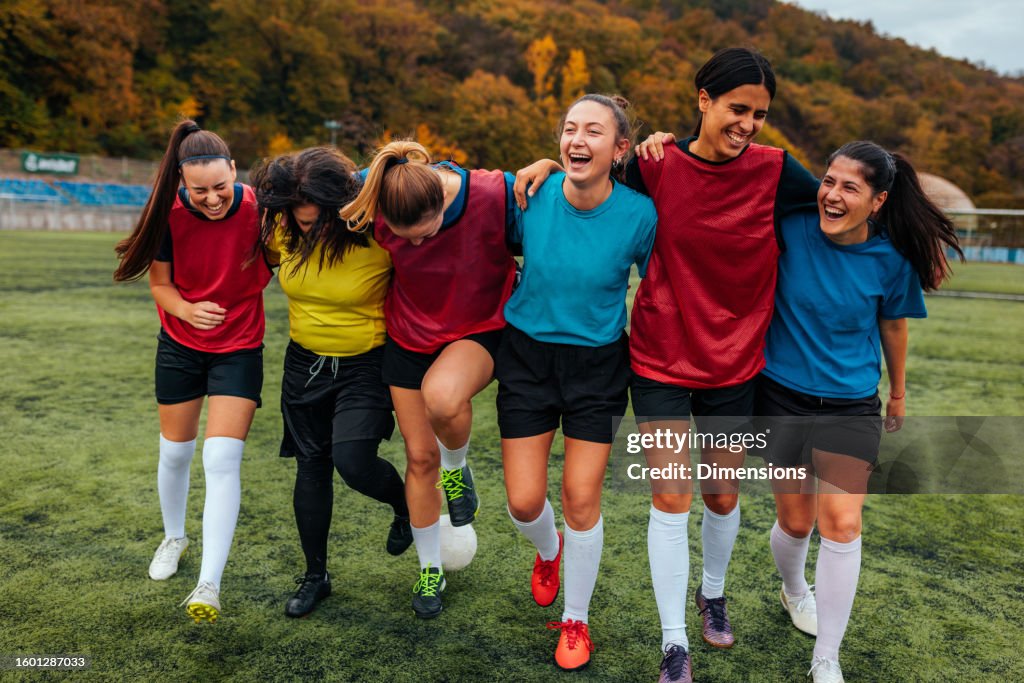Soccer girls bonding on soccer pitch.