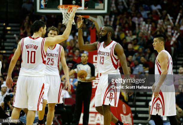 James Harden of the Houston Rockets celebrates a play with Carlos Delfino on the court during the game against the Brooklyn Nets at Toyota Center on...