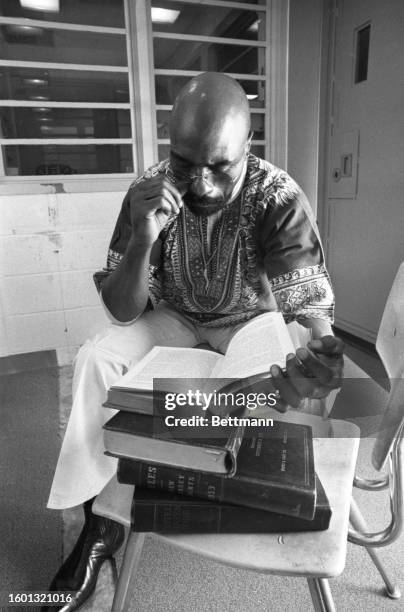 Former middleweight contender, Rubin "Hurricane" Carter reads law books while waiting to talk to reporters at New Jersey's Clinton Correctional...
