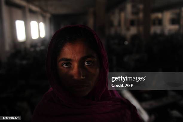 Bangladeshi Shahinur, who worked in this garment factory, looks on in front of the devastation after a fire swept though the premises in Dhaka, on...