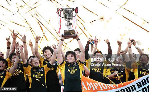 Shinya Makabe of Suntory celebrates with the cup and his team-mates after victory in the Japan Rugby Top League playoff final match between Suntory...